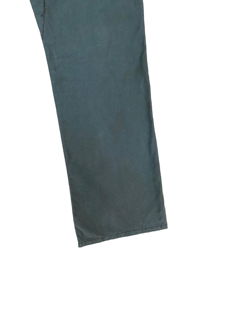 May include: A pair of dark blue trousers with a straight leg.