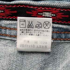 May include: A white care label with washing instructions and a size 40. The label also includes a text that says "染料が色落ちしますので他の物と 一緒に洗わないでください。 タンブラー乾燥は、お避けくたさい。 本体編 100% 前ポケットロ 人工皮革".