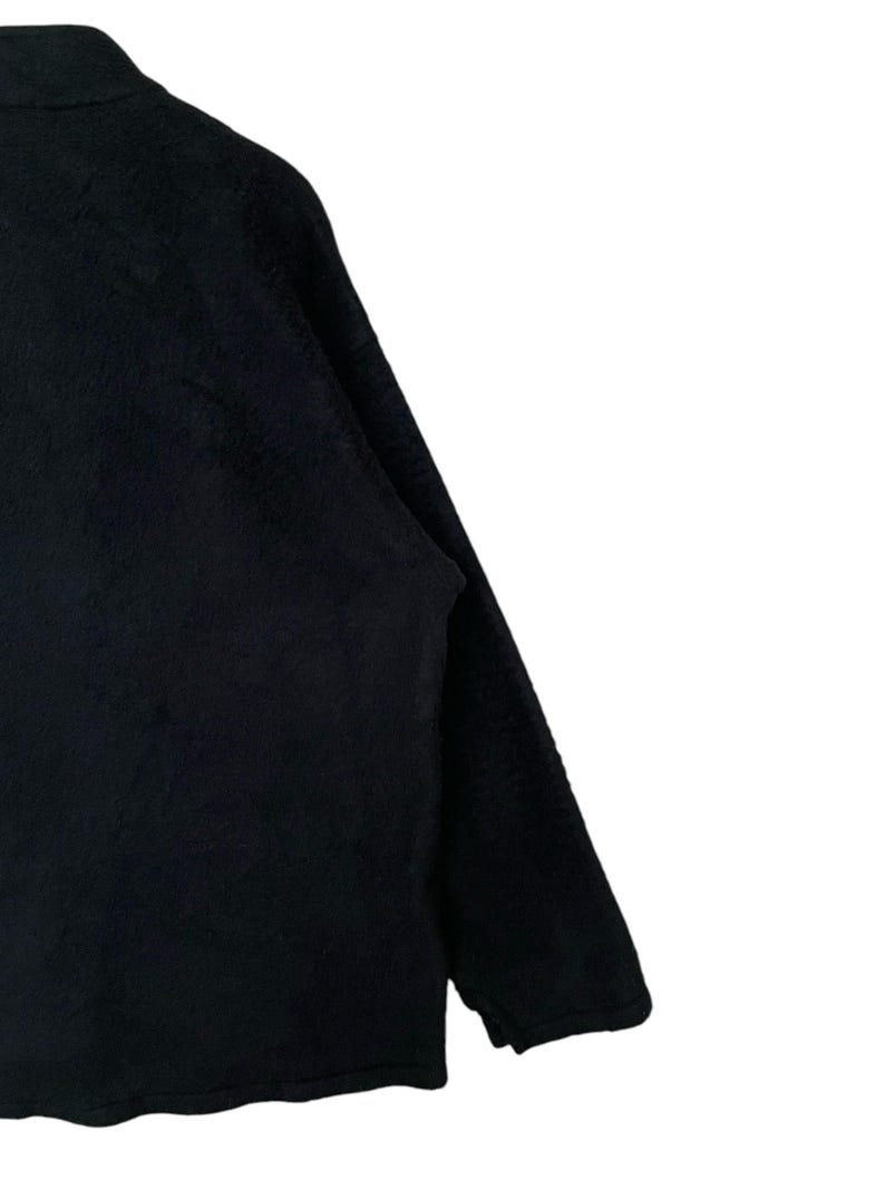 May include: A black long-sleeved sweater with a zipper closure.