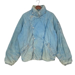 Puede incluir: Una chaqueta vaquera azul claro con cierre de cremallera y varios bolsillos. La chaqueta tiene un forro acolchado y un cuello de pie.