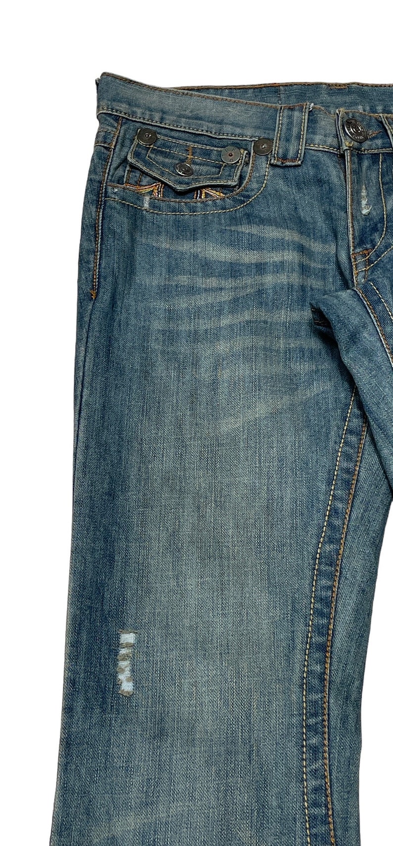 May include: A pair of blue denim jeans with a distressed look. The jeans have a light wash and a faded appearance. The jeans have a classic five-pocket style with a small pocket on the right side of the front.