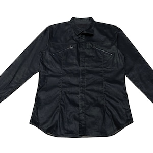 May include: A dark denim long-sleeved shirt with a classic collar and two zipped chest pockets. The shirt has a fitted shape with vertical seams and buttoned cuffs. The fabric has a subtle sheen.