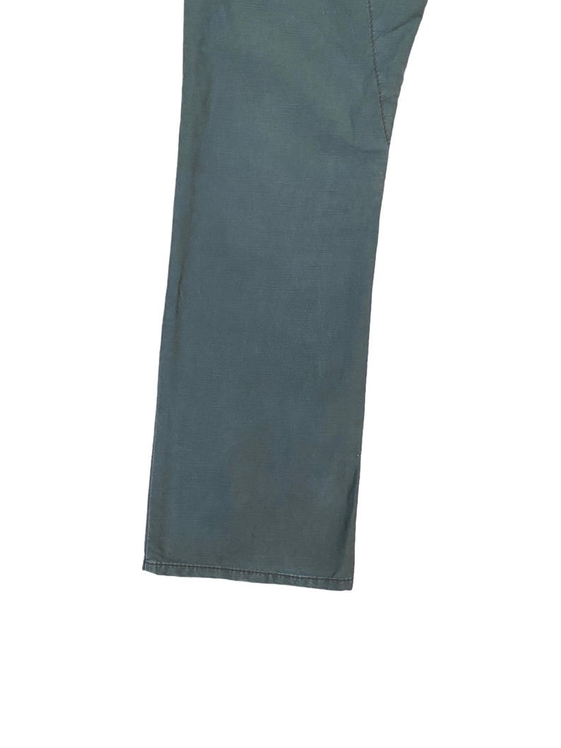 May include: A pair of dark blue denim trousers with a straight leg fit.