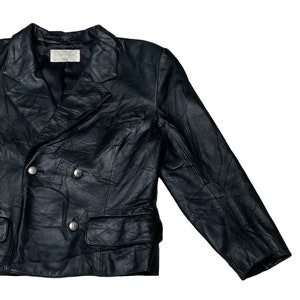 May include: A black leather blazer with a double-breasted closure and two front pockets. The blazer has a  "Couturier" label on the inside.