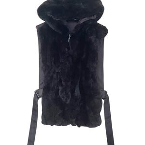 May include: A black faux fur vest with a hood and a zip fastening. The vest has two long ties at the waist.