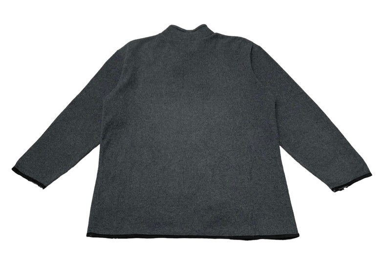 May include: A dark gray long-sleeved sweater with a mock neck and black trim around the neckline and sleeves.