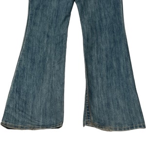 May include: A pair of blue denim flared jeans with a light wash. The jeans have a straight leg and a wide flare at the bottom.