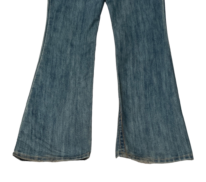 May include: A pair of blue denim flared jeans with a light wash. The jeans have a straight leg and a wide flare at the bottom.