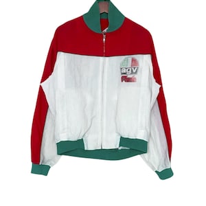 May include: A vintage red, white, and green zip-up jacket. The jacket features red sleeves and upper back, a white front, and green accents on the collar, cuffs, and hem. The chest has a small logo that reads "agv".