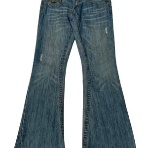 May include: A pair of blue denim jeans with a bootcut style. The jeans have distressed details and a light wash.