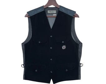 May include: Black corduroy waistcoat with leather accents and a silver star pin. The waistcoat has two front pockets and a button closure.