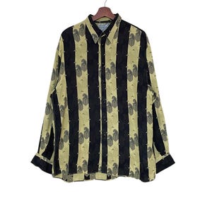 May include: A long-sleeved button-down shirt with a black and tan vertical stripe pattern. The stripes alternate between solid black and tan with a paisley design. The shirt is hanging on a wooden hanger against a white background.