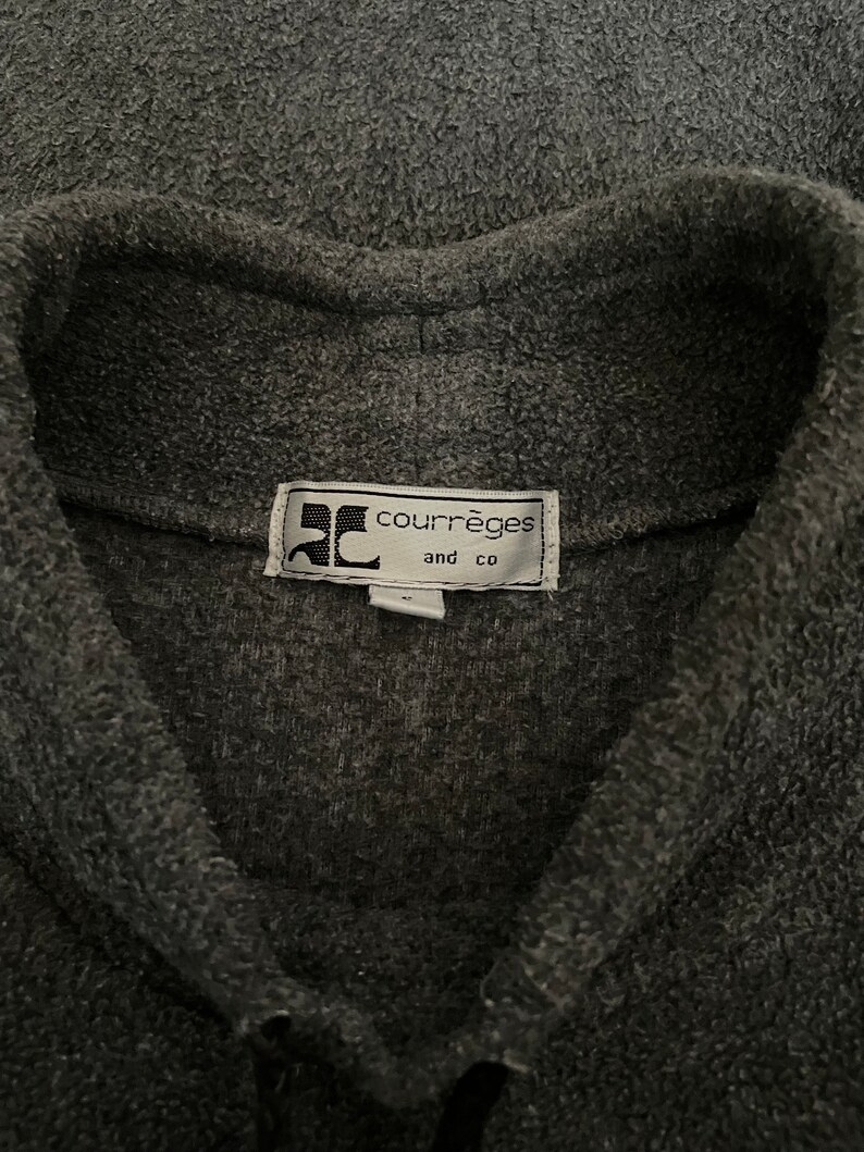 May include: A gray fleece jacket with a black button closure and a label that reads "Courr&egrave;ges and Co."