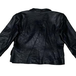 May include: A black leather jacket with a button closure and long sleeves.