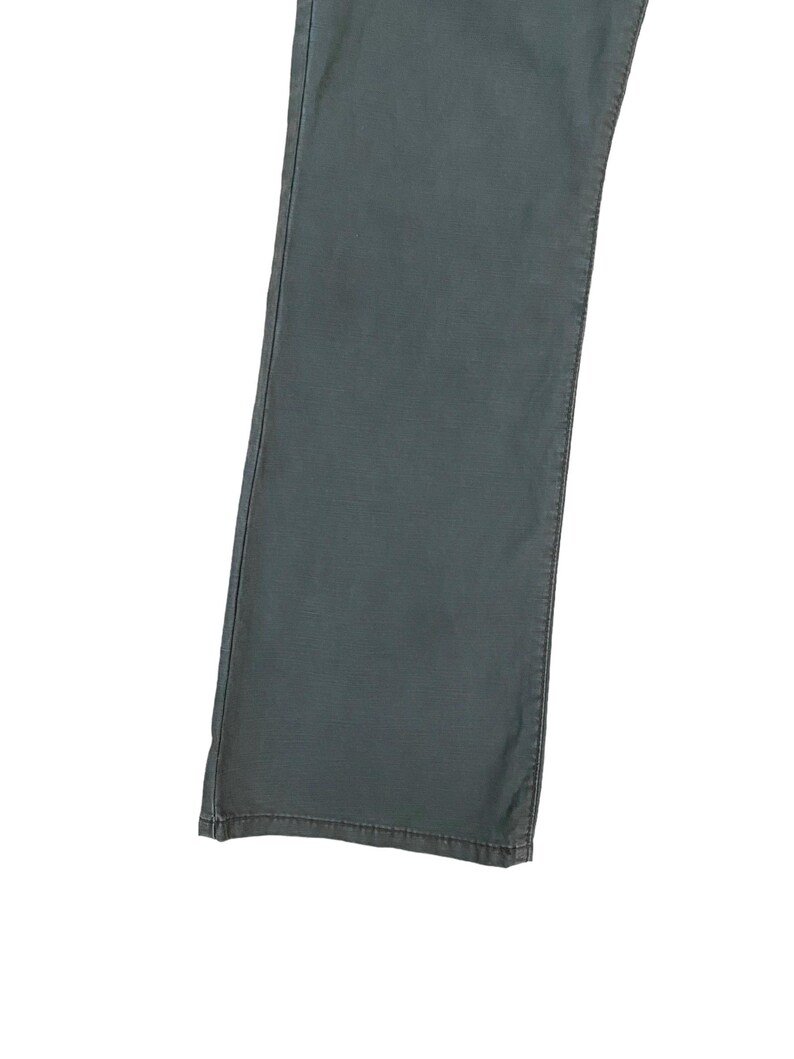 May include: A pair of dark grey trousers with a straight leg fit.
