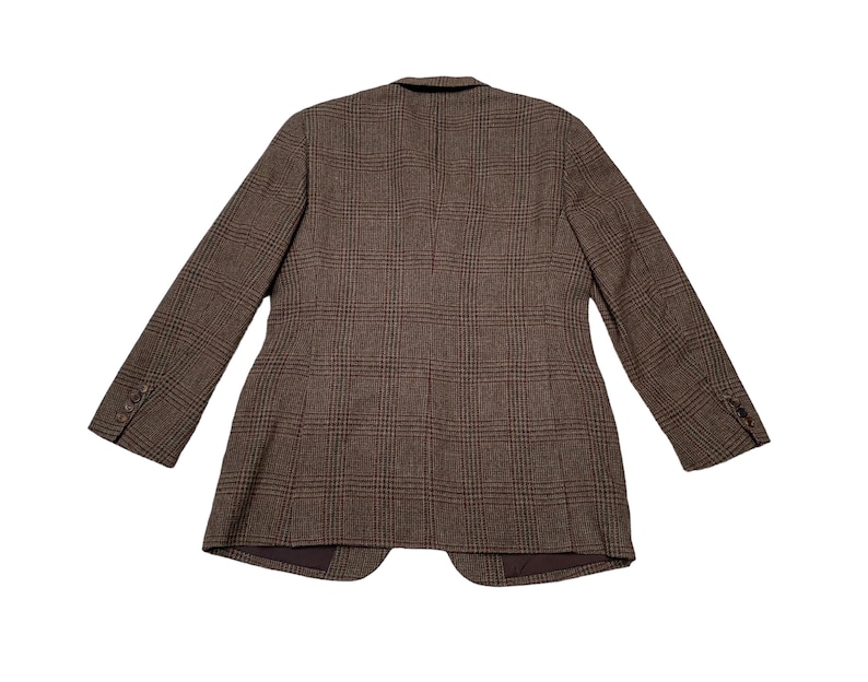 K&ouml;nnte beinhalten: Ein brauner karierter Blazer mit einem Knopfverschluss. Der Blazer hat eine klassische Passform und ist aus einem weichen, bequemen Stoff gefertigt.