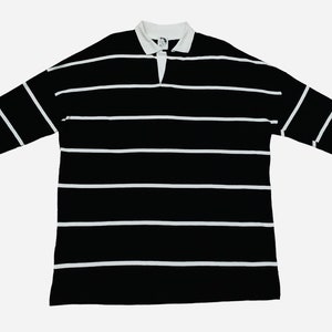 May include: A black and white striped long-sleeve polo shirt.