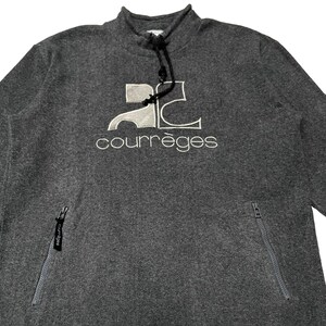 May include: Gray sweatshirt with a white embroidered logo that says "Courr&egrave;ges" and a white embroidered logo of the letter "C" with a stylized "2" inside. The sweatshirt has two zippered pockets on the sides.
