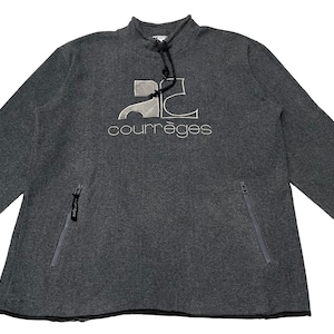 May include: A gray sweatshirt with a white logo that says "Courr&egrave;ges" and a graphic of the letter "C" with a car inside. The sweatshirt has a zippered pocket on the left side.