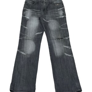 May include: A pair of dark gray denim jeans with distressed details and stitching along the seams.