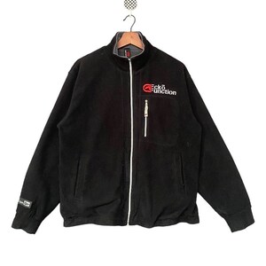 Puede incluir: Chaqueta negra de forro polar con cremallera y un logotipo "ecko unction" rojo y blanco en el pecho.