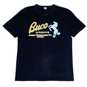 May include: Black t-shirt with a white horse and the text "Buco Horsehide Joseph Buecheleisen Co. Detroit" in yellow.