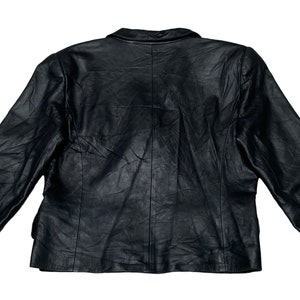 May include: A black leather jacket with a classic design. The jacket has a button closure and long sleeves.