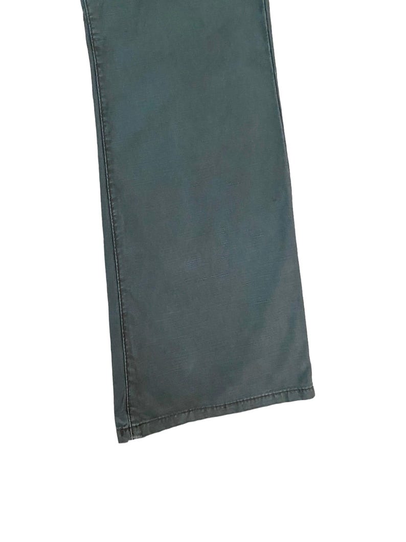 May include: A pair of dark green denim jeans with a straight leg fit.