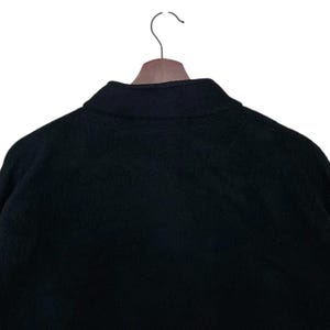 May include: Black fleece jacket with a zipper closure and a stand-up collar.