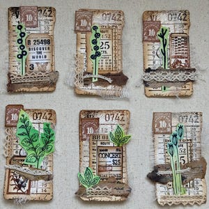 May include: Six handmade collage art pieces featuring vintage ephemera. Each piece includes a postage stamp, ticket stubs, lace, and botanical illustrations. The text "DISCOVER THE WORLD" and "CONCERT $25" are visible on some pieces.
