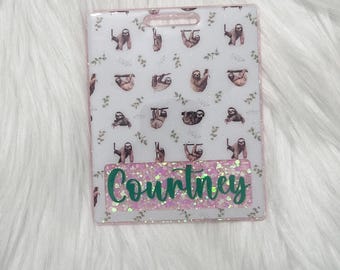 May include: A rectangular badge holder with a pink border and a sloth pattern. The badge holder has the name "Courtney" in green script on a pink glitter background.