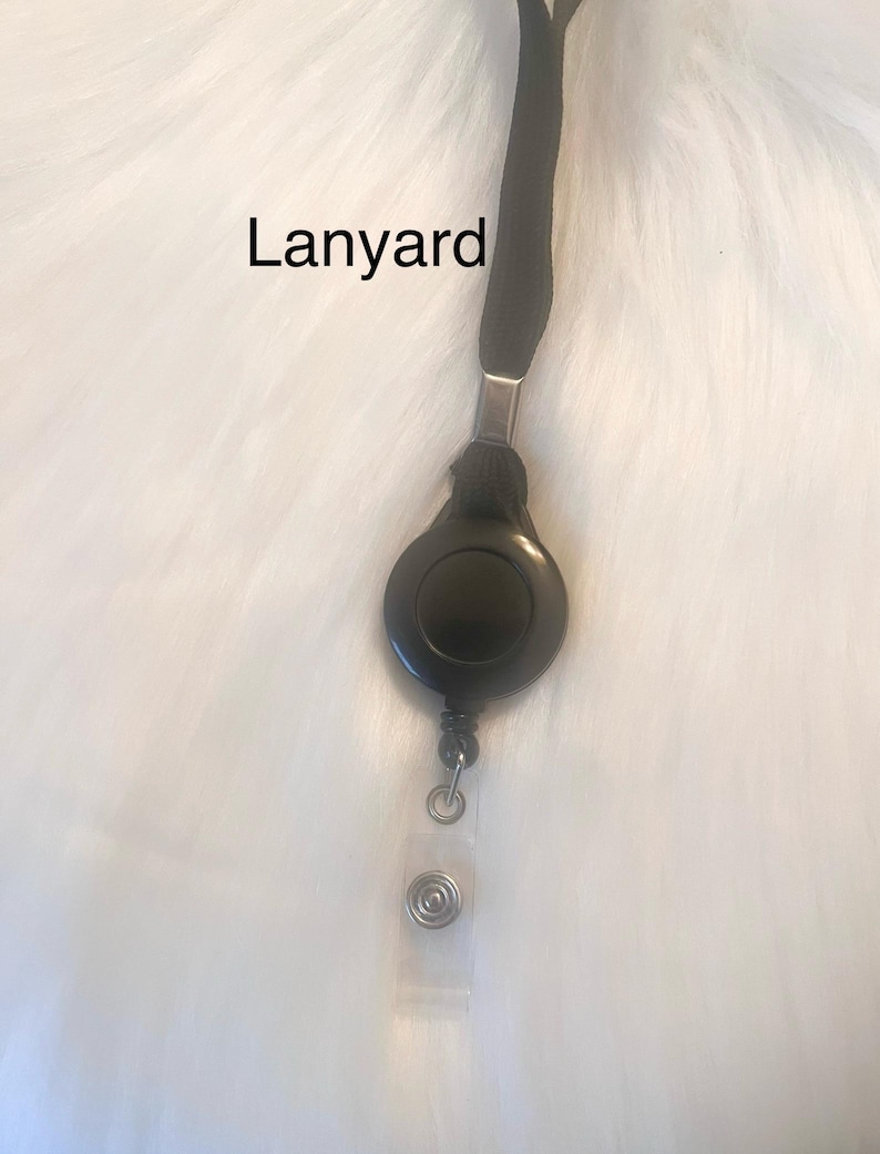 May include: Black lanyard with a retractable badge reel. The reel is round and black, with a clear plastic strap and a metal clip. The word "Lanyard" is printed on the image.