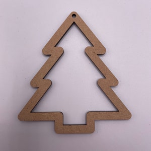Peut inclure: Une décoration de Noël en bois brun en forme d'arbre avec un trou en haut pour l'accrocher.
