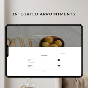 May include: A digital tablet displays a website interface with the text "INTEGRTED APPOINTMENTS." The screen shows a wooden bowl of fruit and appointment options. The website's design is clean with a neutral color palette.