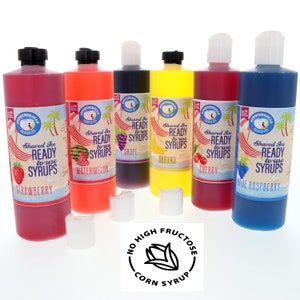 May include: Six bottles of shaved ice syrup in various flavors: strawberry, watermelon, grape, banana, cherry, and blue raspberry. The bottles are labeled with the flavor and the words "Shaved Ice Ready to Use Syrups". The bottles are arranged in a row on a white surface. A sticker with the text "No High Fructose Corn Syrup" is in the foreground.