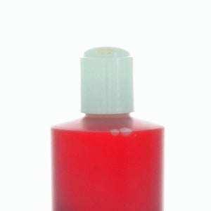 May include: A red plastic bottle with a white pump top. The bottle is filled with a red liquid.