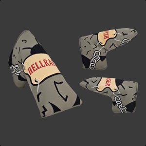 May include: Three gray golf club head covers with chain and skull designs. The covers have the words "Hellraiser" and "User" printed on them.