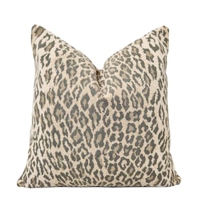 May include: A beige and gray throw pillow with a leopard print pattern.
