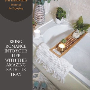 May include: A white bathtub with a wooden tray holding a candle, succulent, and fern. A rolled white bath mat with fringe sits on the tub's edge. The text on the left says, "BRING ROMANCE INTO YOUR LIFE WITH THIS AMAZING BATHTUB TRAY."