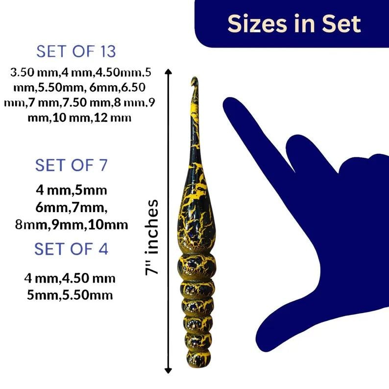 K&ouml;nnte beinhalten: Ein Set mit 13 H&auml;kelnadeln in verschiedenen Gr&ouml;&szlig;en von 3,50 mm bis 12 mm. Die Nadeln sind aus schwarzem und gelbem Kunststoff mit einem Marmormuster. Die Nadeln sind 17,8 cm lang. Das Bild zeigt auch eine Hand, die eine der Nadeln h&auml;lt.