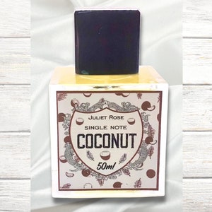 May include: A yellow glass bottle with a black cap and a label that says "Juliet Rose Single Note Coconut 50ml". The label has a brown and white design with coconuts and leaves.