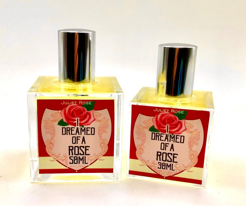Puede incluir: Dos botellas de vidrio transparente con tapas plateadas y l&iacute;quido amarillo en su interior. Las etiquetas son rojas con texto blanco que dice "Juliet Rose I Dreamed of a Rose 30ML".