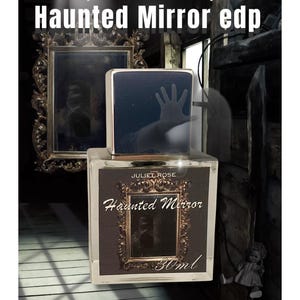 May include: A perfume bottle with the text "Haunted Mirror edp" and "Juliet Rose" on the label. The bottle has a dark, rectangular design with a hand silhouette on the top. The label features a framed mirror design. The bottle contains 30ml.