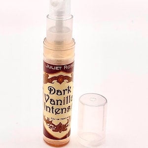 以下が含まれることがあります： 「Juliet Rose Dark Vanilla Intense Eau de Parfum」とラベルされた小さな香水瓶。ボトルは透明で、スプレーノズルと透明なキャップが付いています。ラベルは茶色と金色で、装飾的な文字が施されています。
