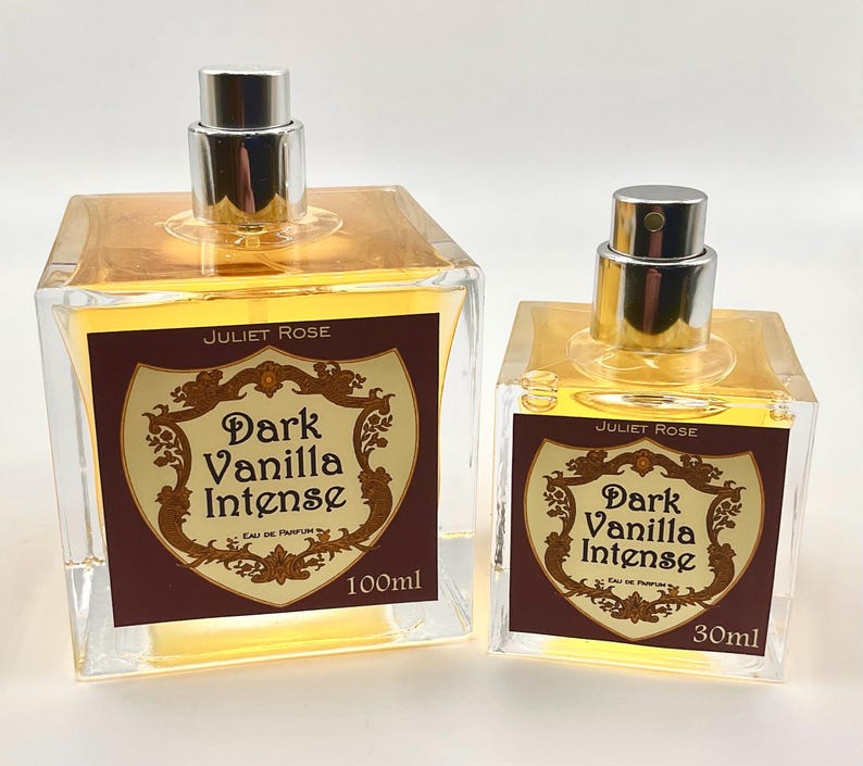 May include: Two glass perfume bottles with silver spray tops. The bottles are filled with a golden liquid and have labels that read "Juliet Rose Dark Vanilla Intense Eau de Parfum". The larger bottle is 100ml, the smaller is 30ml.