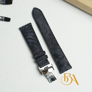 Puede incluir: Dos correas de reloj de cuero negro con un patrón texturizado. Las correas tienen hebillas plateadas.