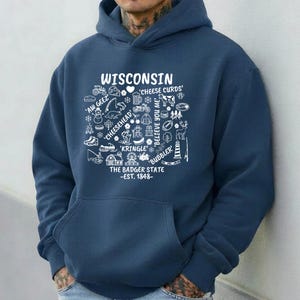 May include: Navy blue hoodie with a white graphic design featuring the word "WISCONSIN" and various state-related icons and text, including "Cheese Curds" and "The Badger State - Est. 1848."