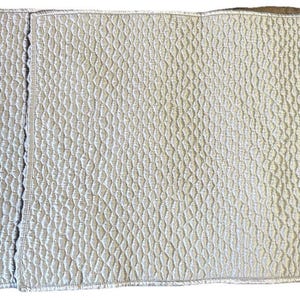 May include: A light blue quilted fabric with a diamond pattern. The fabric is folded in thirds, with a vertical seam down the center. The texture appears soft and inviting, suitable for bedding or upholstery.