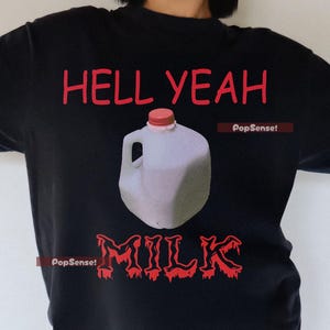 May include: Black t-shirt with a red graphic of a milk jug and the text "Hell Yeah Milk" in red. The text "PopSense!" appears twice in red at the bottom of the graphic.