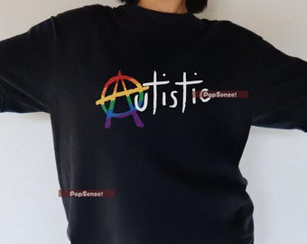 Könnte beinhalten: Schwarzes T-Shirt mit einem Regenbogen-Anarchie-Symbol und dem Wort "autistic" in weißer Schrift. Ein lässiges Oberteil, ideal für den Alltag.